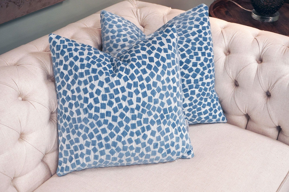 Geometric throw pillow in light blue with repeating square mosaic pattern
