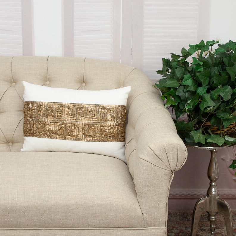 Lumbar throw pillow with light sage cover and gold-brown embroidered geometric band