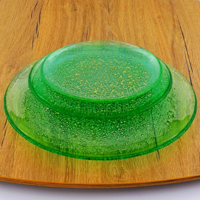 Emerald glass dinner plate with gold speckled center and clear rim detail.