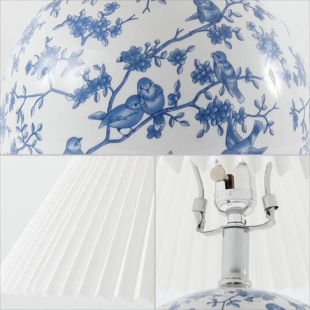 Blue and white porcelain lamp with bird and flower design, featuring a pleated white shade and silver base.