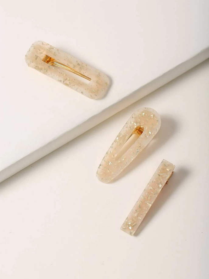 Three translucent sparkle resin hair clips with gold prongs; mix of oval and rectangular.