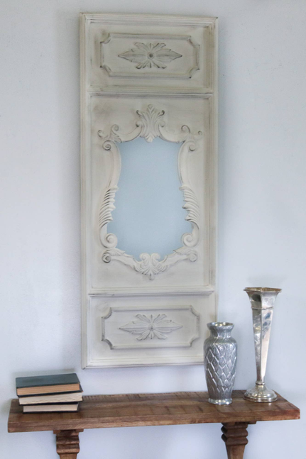 White ornate wall mirror with floral pediment and arched center panel