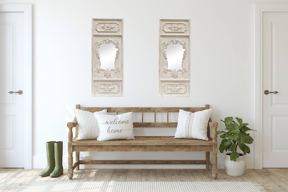 Two white ornate wall mirrors with floral crest and arched center panels above a bench