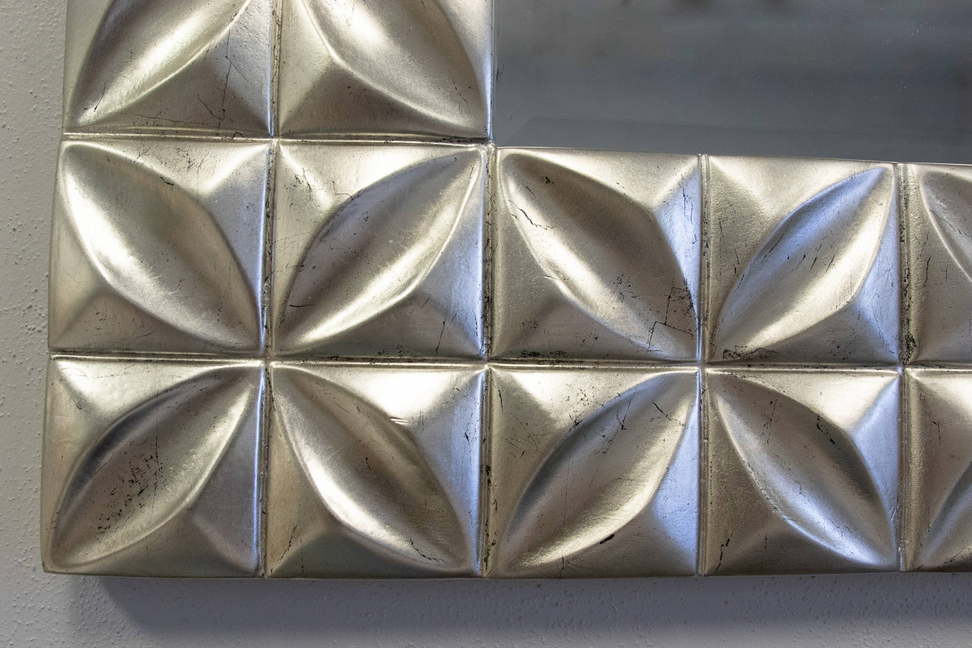 Close-up of silver distressed mirror tile frame with raised square diamond facets.