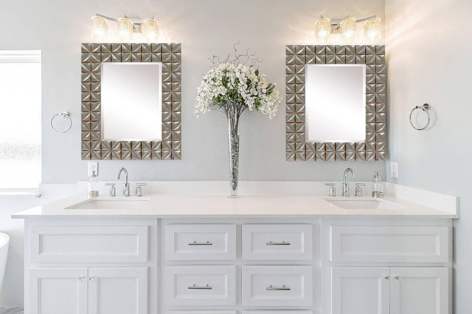 Silver square wall mirror with faceted tile frame on bathroom vanity wall.