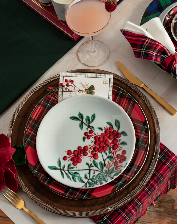 Porcelain dinner plate with red berry motif, green leaves, and dark plaid border