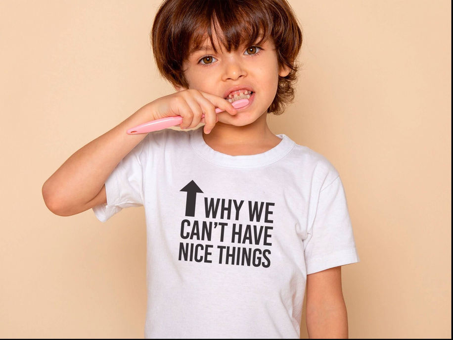White kids T-shirt worn by child, 'Why we can't have nice things' arrow slogan