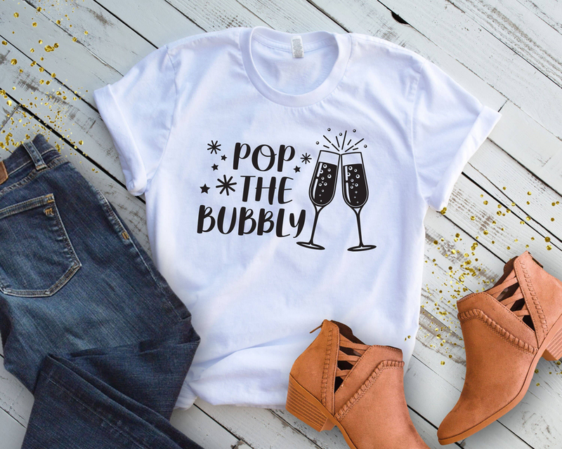 White crewneck tee with short sleeves and 'Pop the Bubbly' champagne glasses
