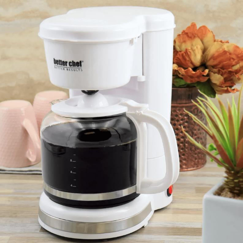 White coffee maker on countertop with water tank and black carafe