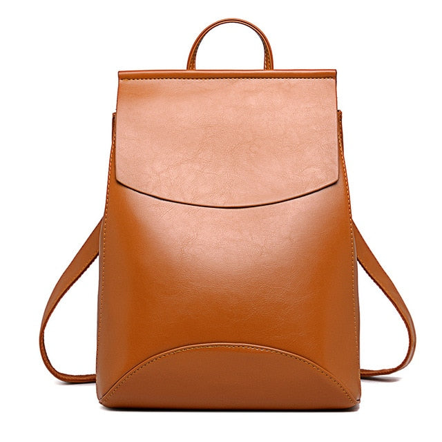 Tan brown leather backpack with front flap and top handle, side shoulder straps