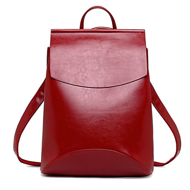 Red leather backpack with front flap and top handle, side shoulder straps