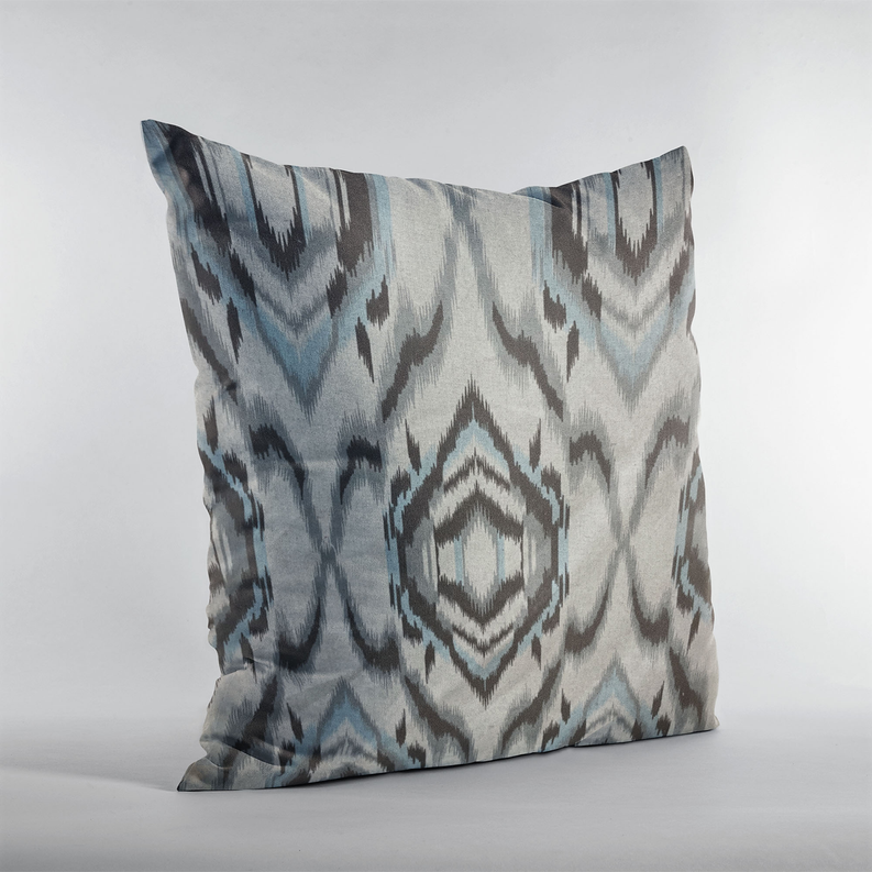 Ikat throw pillow angled view with chevrons and diamond medallion in cream and blue