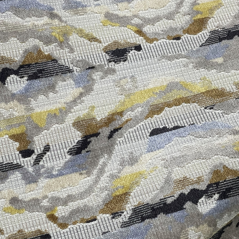 Decorative pillow close-up with woven gray, black, and yellow abstract motif