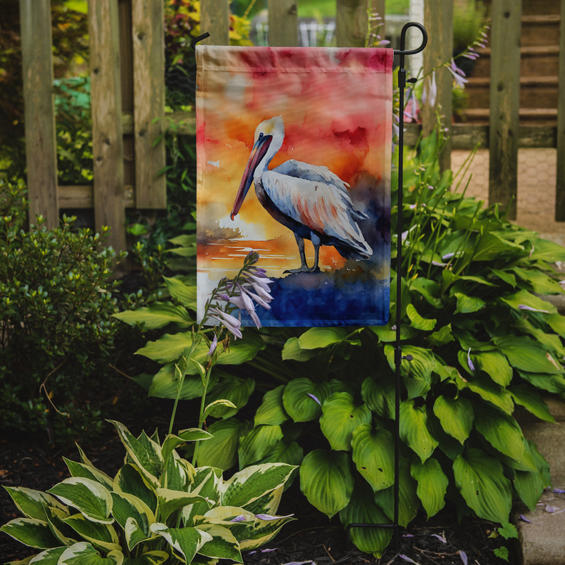 Pelican garden flag hanging on a pole with red-orange watercolor art.