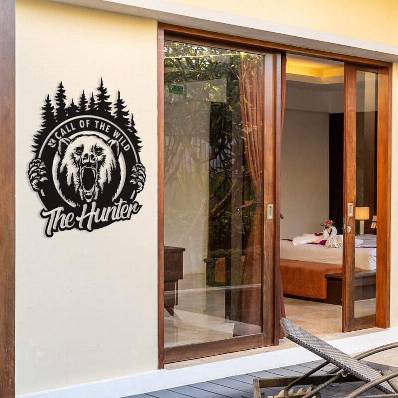 Metal wall art of roaring bear logo with trees, black design on light surface