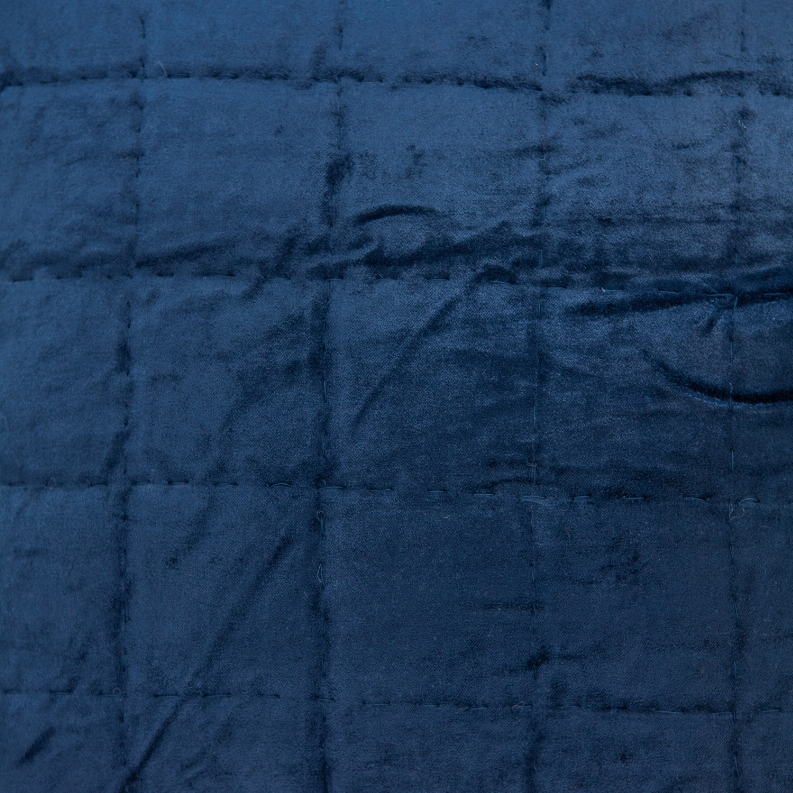 Close-up of navy blue quilted throw pillow fabric with stitched channels