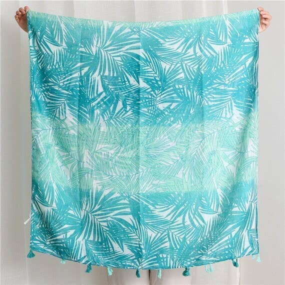 Turquoise leaf-pattern scarf, folded with tassel fringe at the bottom