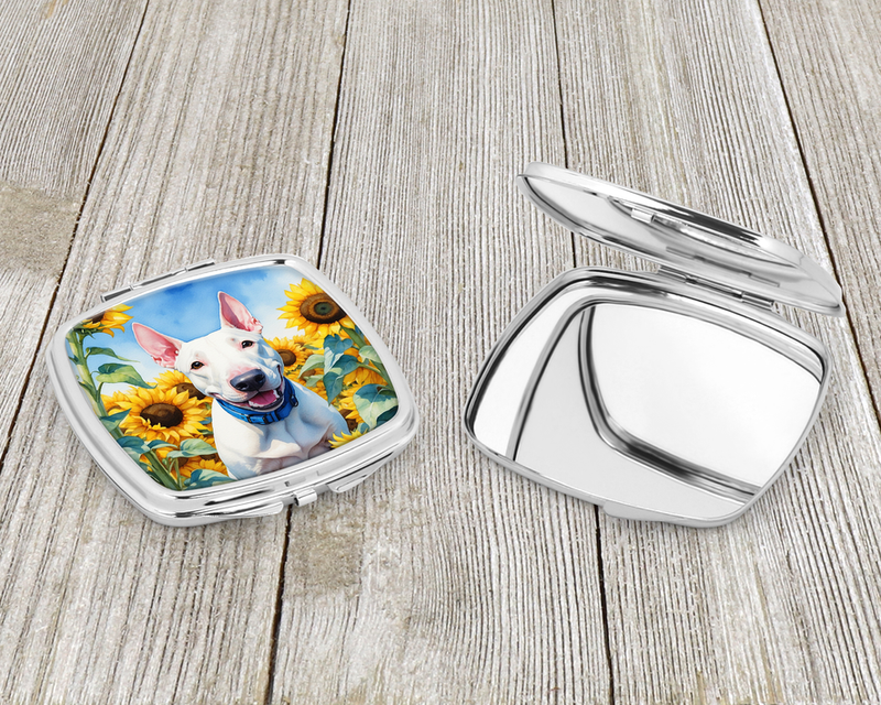 Compact mirror set with open silver case and white dog in sunflower garden photo