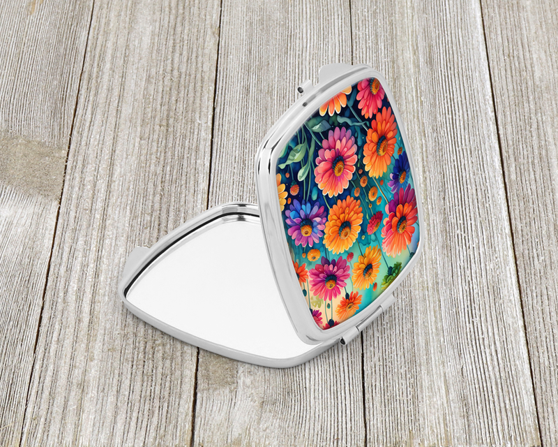 Compact mirror with open lid, silver frame, colorful zinnia-style floral design.