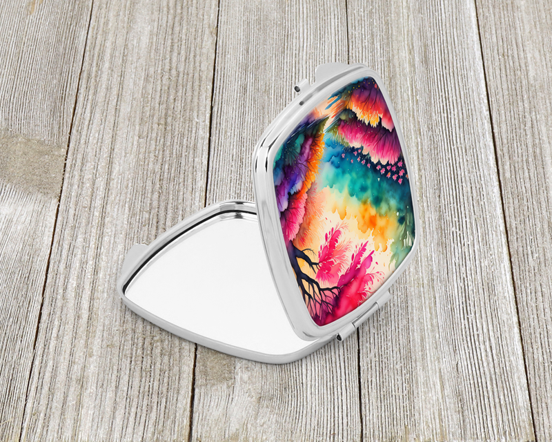 Compact mirror open with silver frame and colorful rainbow floral landscape on lid