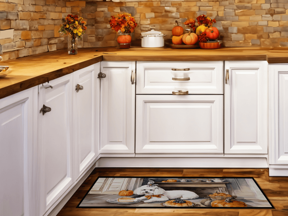 White candle jar on kitchen counter with fall pumpkins and autumn decor