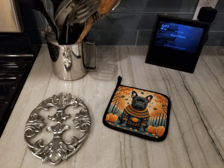 Rectangular pot holder with a black dog and pumpkins on an orange fall background