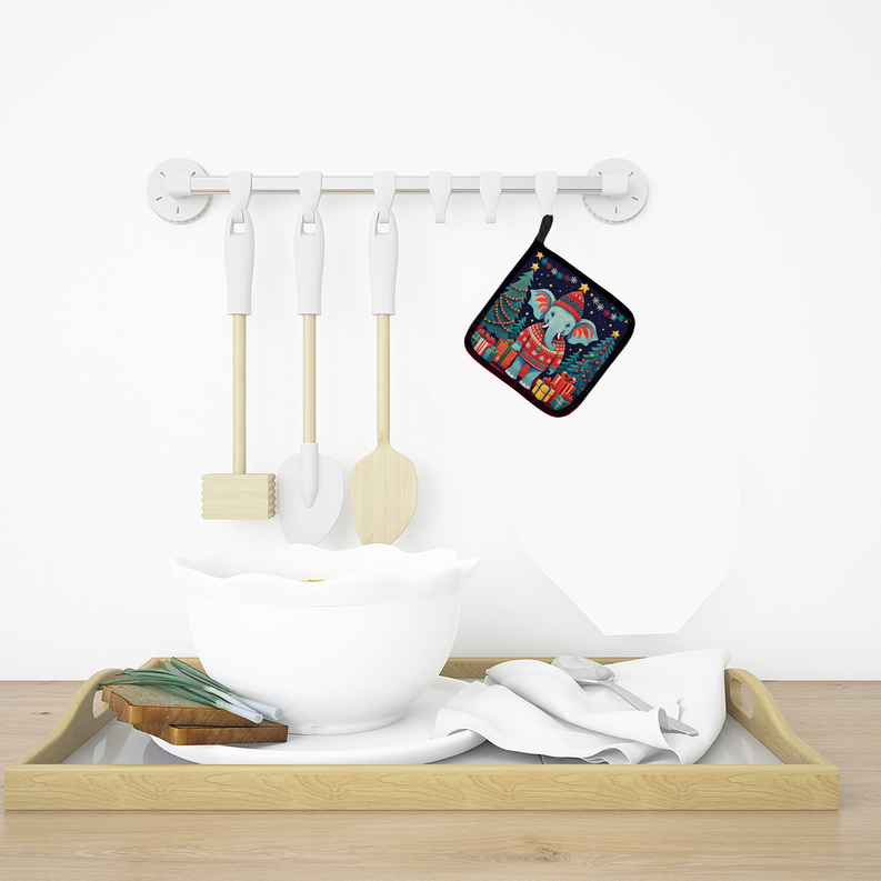 Elephant-themed Christmas pot holder hanging on wall hooks with matching kitchen tools