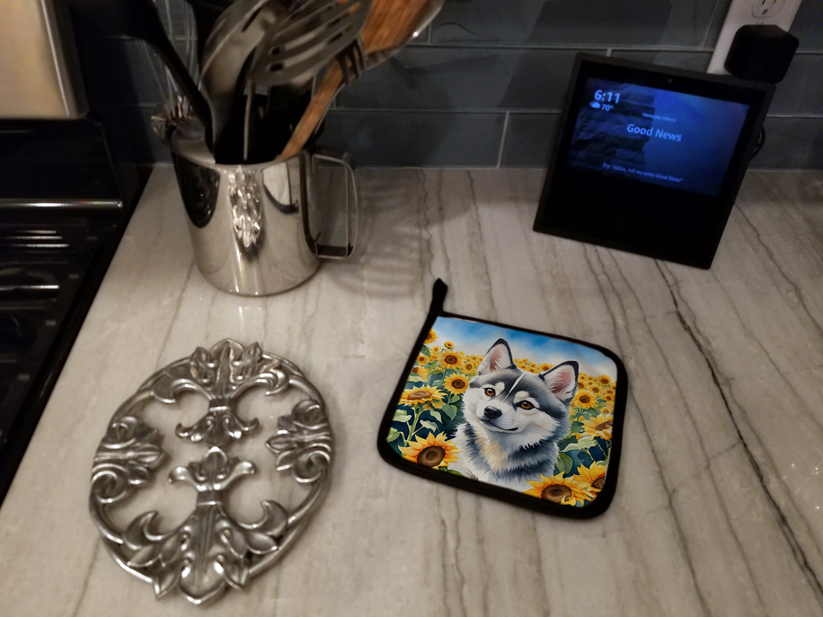 Alaskan Klee Kai sunflowers pot holder on a kitchen floor near a stove