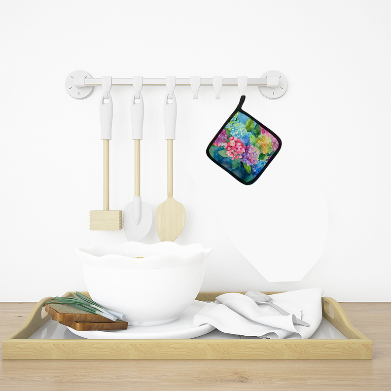 Hanging watercolor pot holder with multicolor floral design on a white kitchen wall rack.