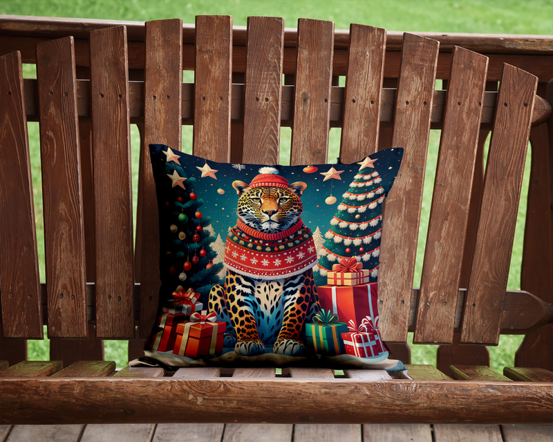 Blue outdoor throw pillow with leopard in red knit sweater on wooden bench