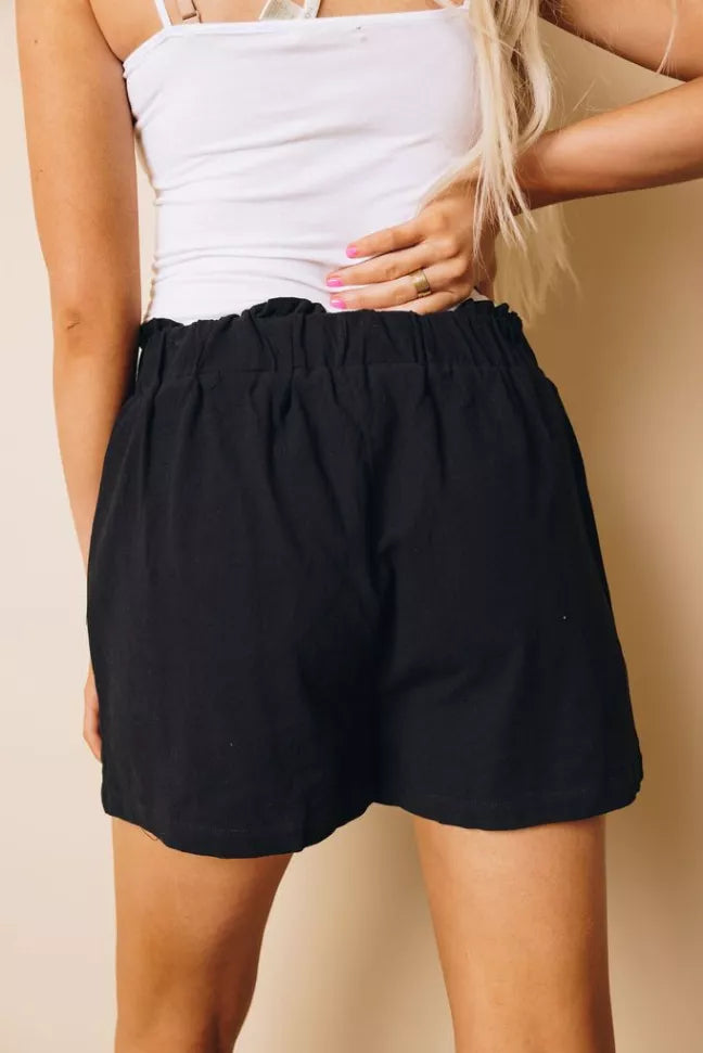 Black elastic-waist shorts with side pockets, front view