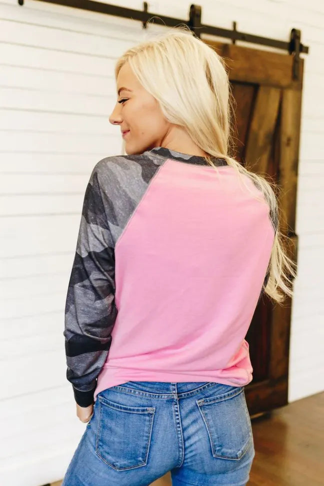 Pink crewneck pullover with dark camo long sleeves, back view