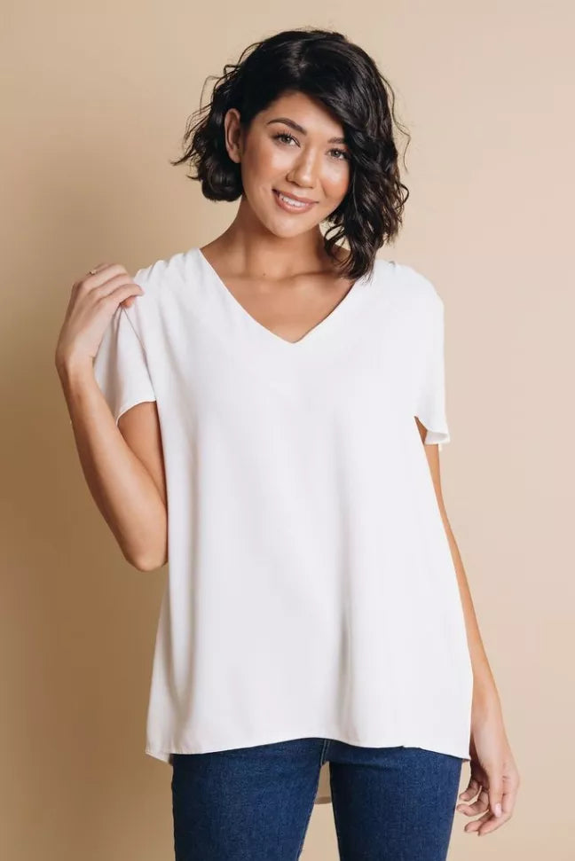 White short-sleeve top with V-neck, relaxed fit, front view