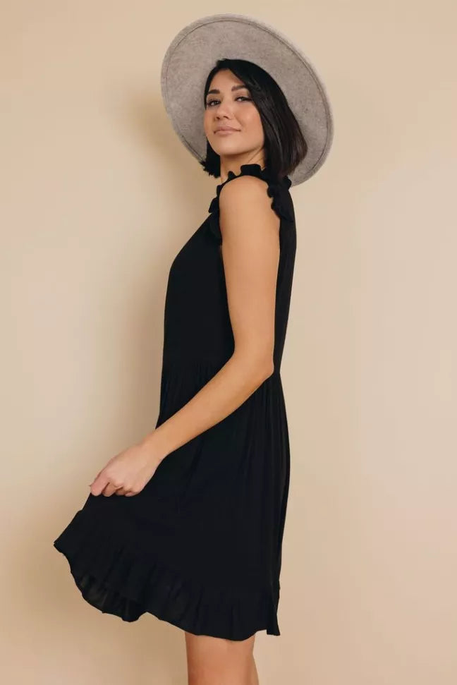Black sleeveless ruffle dress side view with tiered swing hem