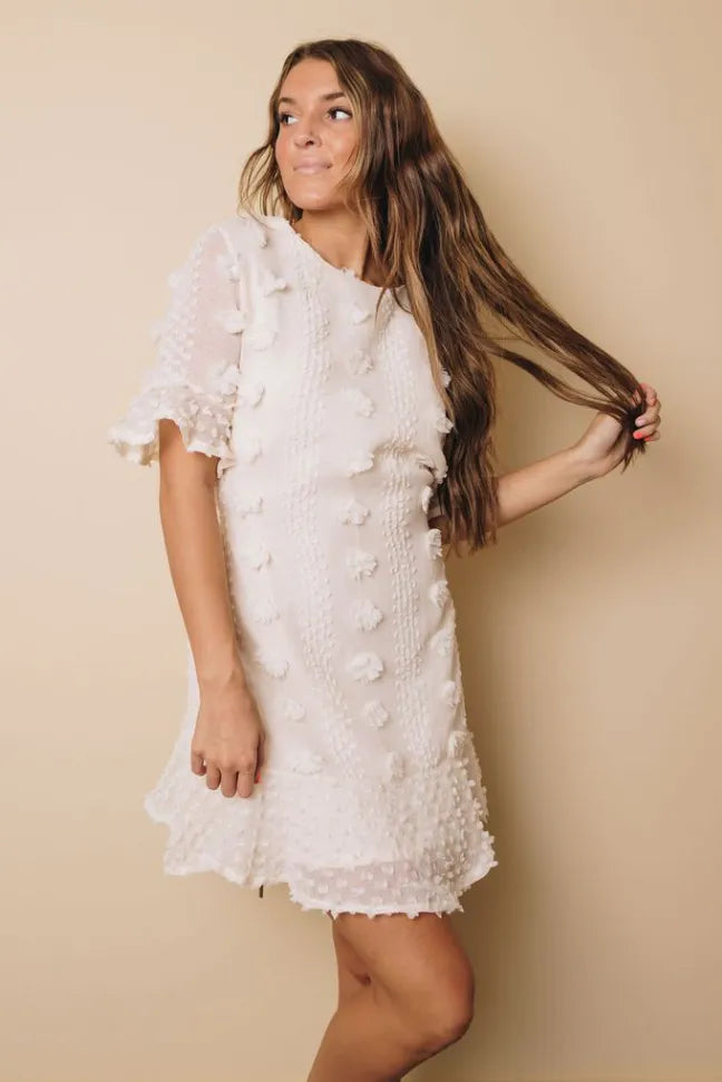 White swiss dot mini dress with short ruffled sleeves and textured dot pattern