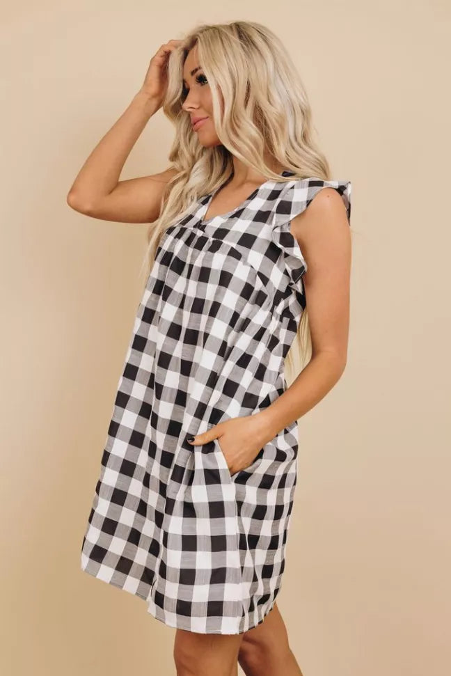 Black-and-white plaid sleeveless ruffle dress with side pocket, angled view