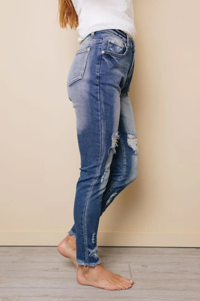 High-rise skinny jeans, light blue distressed wash, back patch pockets, ripped knee