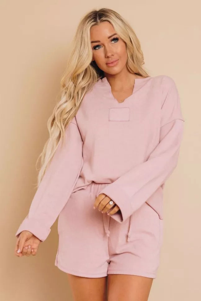 Pink loungewear set with long sleeves and matching shorts, front view.