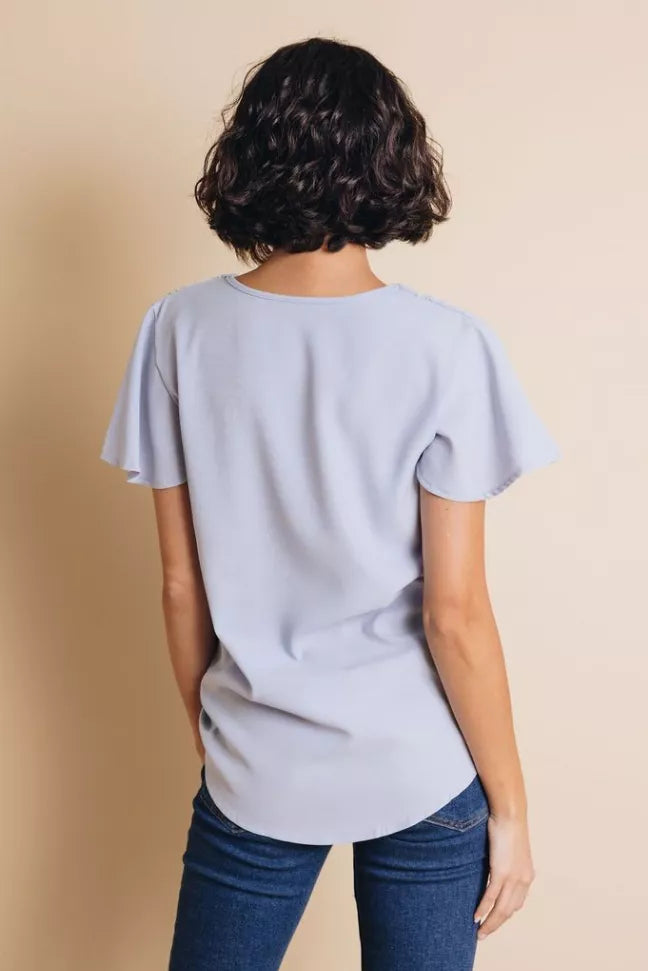 Light blue short-sleeve top, scoop-back view with relaxed fit