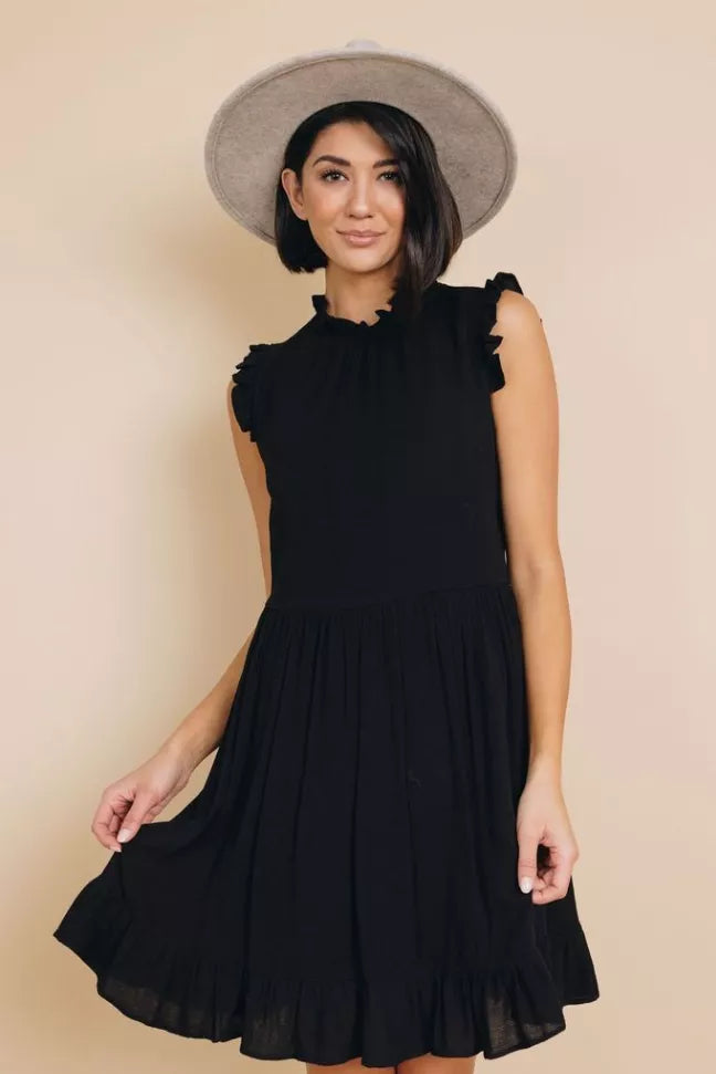 Black sleeveless ruffle dress with high neckline and pleated tiered skirt