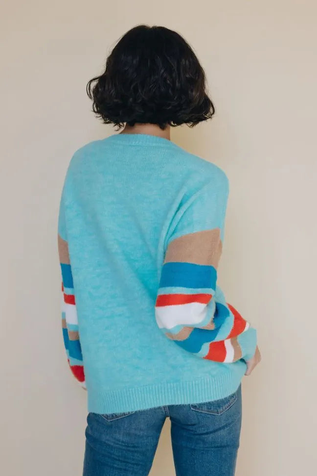 Light blue crewneck striped sweater with multicolor stripe sleeves, back view with arm detail