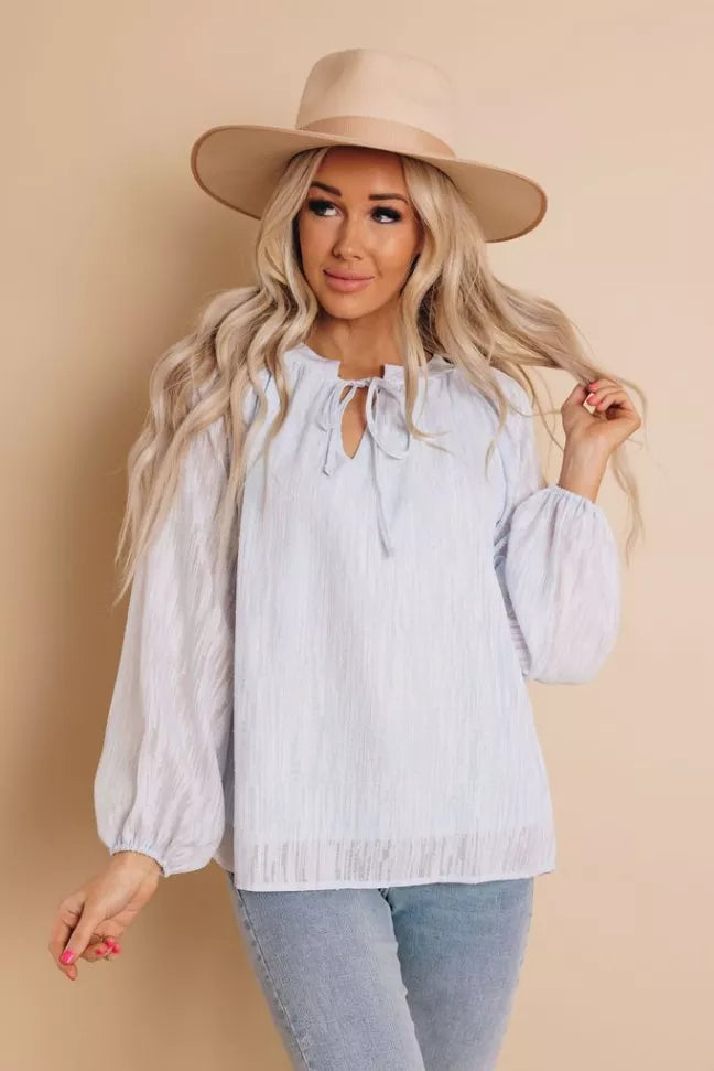 White long-sleeve peasant top with keyhole neckline, neck tie, and puff sleeves