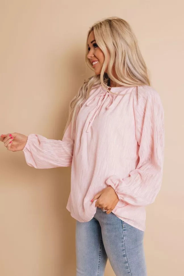 Light pink peasant blouse with tie neckline, long sleeves with elastic cuffs