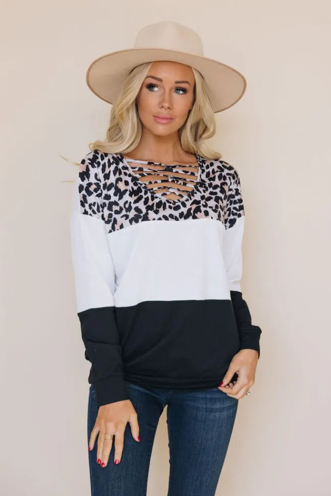 Leopard print long sleeve top with crisscross neckline, white body and black lower
