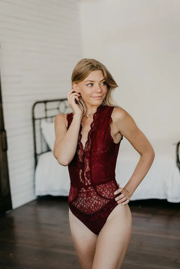 Wine lace bodysuit with sleeveless design, high neckline, and lace bodice