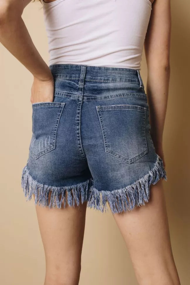 Women's blue denim shorts with frayed tassel hem and front patch pockets