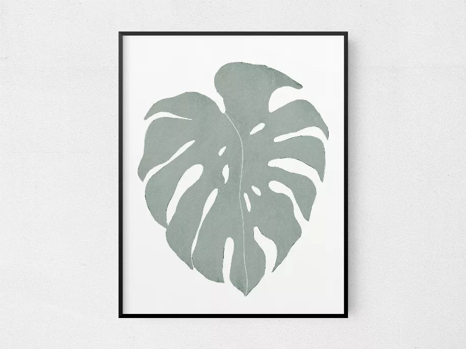 Framed monstera leaf wall print with muted green leaf shape on white