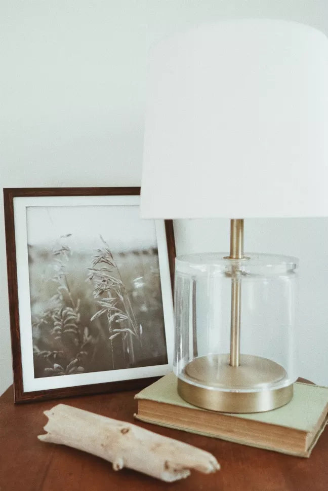 Wood-framed plant field photo print with beige grasses on a small tabletop