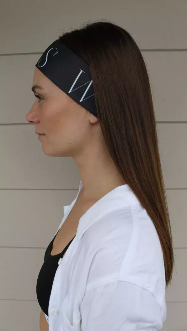 Black sport headtie with light geometric print, worn with hair pulled back