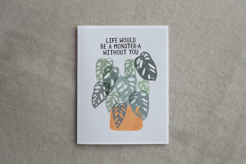 Framed monstera leaf wall art with quote, white border on textured fabric background.
